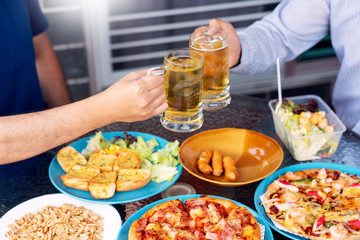 leisure, holidays with beer grilled meat and vegetables served, Young People chatting and having drinks together enjoying outdoor garden party and celebrating evening Meal.