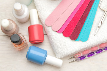 Manicure. nail polishes and various accessories and tools for manicure on a white wooden table. top view
