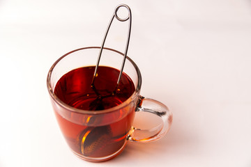 Glass cup mug with black tea with a tea strainer isolated on a white background