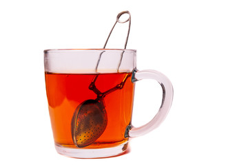 Glass cup mug with black tea with a tea strainer isolated on a white background