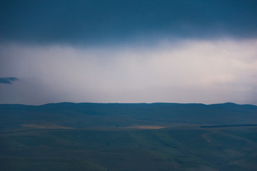 Overcast clouds in the distance over the hills