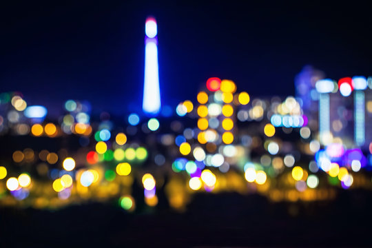 Night bokeh city light with illuminated TV tower, abstract blur defocused background