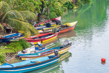 Fototapeta na wymiar Colorful fishing boats docked on river bank on tropical Caribbean island