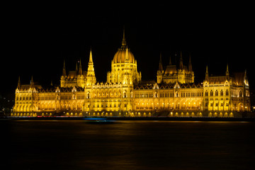 Obraz na płótnie Canvas BUDAPEST, HUNGARY - MAR 07th, 2019: The Hungarian Parliament Building is the seat of the National Assembly of Hungary at the Danube river during night, one of Europe's oldest legislative buildings
