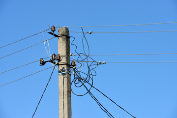 Upper part of utility pole with many wires and insulators.