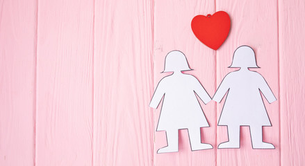 Lesbian Couple Together Concept . Two paper woman on pink background.