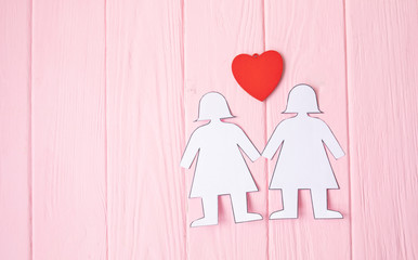 Lesbian Couple Together Concept . Two paper woman on pink background.