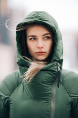 Fototapeta premium Photo of blonde with long hair in green jacket on blurred background