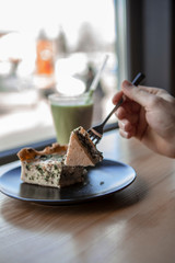 A photo of real food at a fast-service coffee shop. Pie with spinach and broccoli and a green smoothy strip
