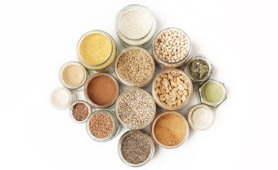 Top view of jars with grains, seeds, legumes, flours and various food ingredients. Healthy food concept.