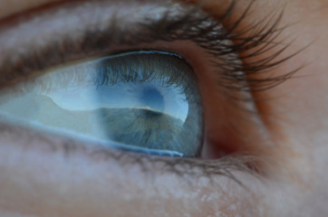Reflection of Mount Elbrus in a blue human eye close up