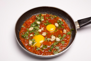 vegetable omelet in a black iron pan On a white background