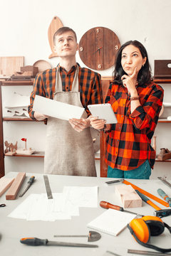 Thoughtful Man And A Woman Colleagues In The Workshop Studio. Concept Of Handwork And Carpentry