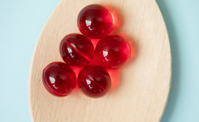 medicine tablets on a wooden spoon isolate on blue background.