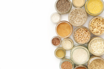 Top view of jars with grains, seeds,legumes, flours and various food ingredients. Healthy food concept.