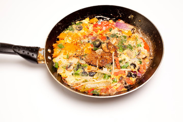 vegetable omelet in a black iron pan On a white background