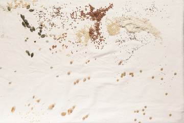 Various food ingredients on the white tablecloth.Sunflower, chia, pumpkin seeds, oats, chickpeas and flour