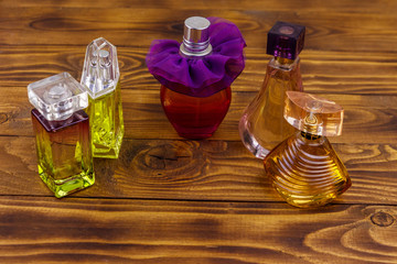 Different bottles of perfume on the wooden background