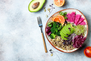 Vegan, detox Buddha bowl with quinoa, micro greens, avocado, blood orange, broccoli, watermelon radish, alfalfa seed sprouts. Top view, flat lay, copy space