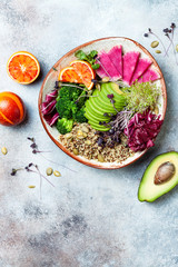 Vegan, detox Buddha bowl with quinoa, micro greens, avocado, blood orange, broccoli, watermelon radish, alfalfa seed sprouts. Top view, flat lay, copy space