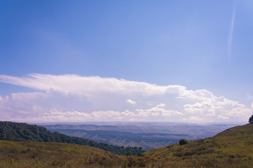 Obraz premium A huge panorama of the impending huge dark blue clouds over the mountains and hills in the summer