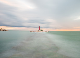 Fototapeta premium view of a lighthouse on a cloudy day in long exposure