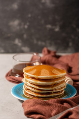 Pancake folded stack of with liquid honey and sugar powder on stone background