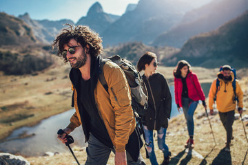 Group of hikers walking on a mountain at autumn day