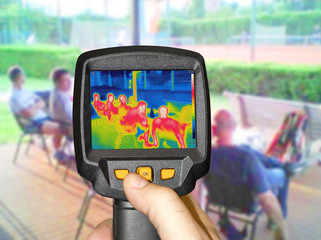 Recording whit Infrared thermovision camera when People sit at the table in the summer