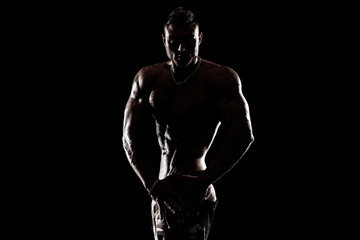 Fototapeta na wymiar Bodybuilding competitions on the scene. Man sportsmen physique and athlete. Black background.