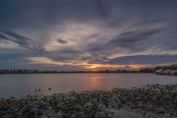 Lake view evening of many clouds moving in the sky with colorful red sun light in the sky background, sunset at Krajub reservoir, Banpong, Ratchaburi, Thailand.