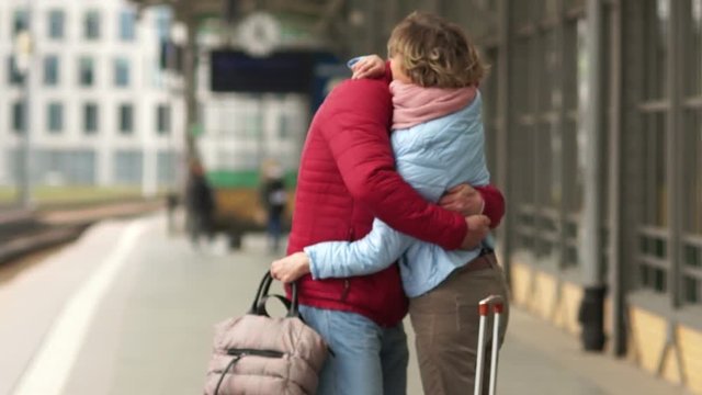 Mature woman meets at the station her husband from the trip. Long-awaited meeting