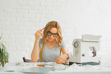 beautiful young girl in a factory with a sewing machine at the table