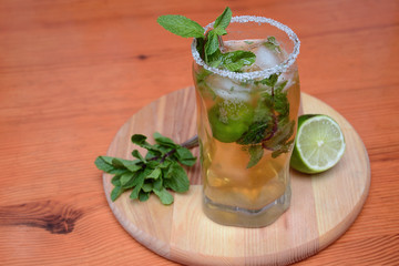 mojito drink in glass dish, on wooden table