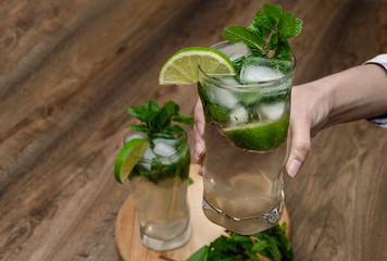 female hand holds a glass with a mojito drink