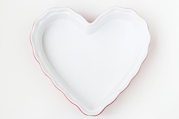Fototapeta na wymiar Ceramic form in the form of a heart is located on a white background