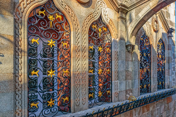 Obraz premium Close-up view of an ancient window with ornate decorated metal bars in an old limestone fortification wall.