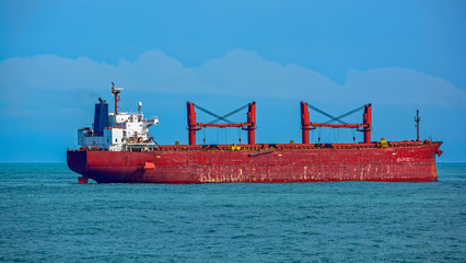 Bulk carrier vessel is awaiting loading of bauxite ore at outer anchorage of Kamsar port, Guinea,...