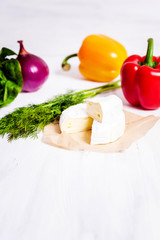 Fototapeta na wymiar Cheese and vegetables on a white background