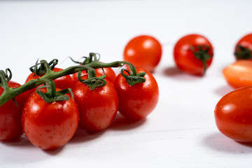 Fresh cherry tomatoes on a white wood background.
