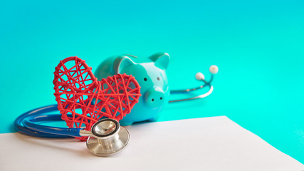 Piggy bank with stethoscope isolated on blue background. tax offset concept. Medical Expense Deductions and Tax Breaks