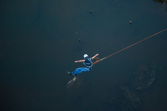 Extreme jump from the bridge. The man jumps surprisingly quickly in bungee jumping at Sky Park explores extreme fun. Bungee in the canyon.
