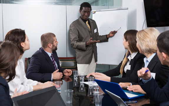 man giving presentation to colleagues at international business meeting