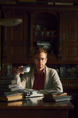 Young man writing on old typewriter.