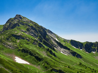 High mountain with snow on top against a clear blue sky.