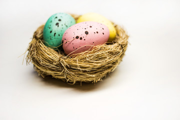 Naklejka na ściany i meble Easter eggs in a basket on a white background