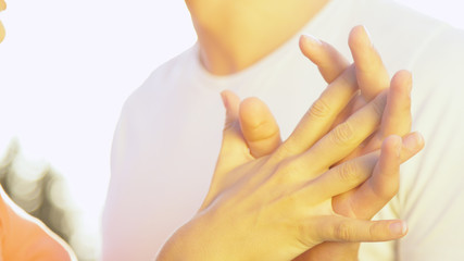 CLOSE UP: Unrecognizable man and woman interlock fingers during their date.