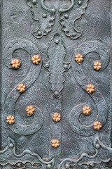 Vintage steel door decorated with wrought iron, pattern fragment of door to the cathedral in Lviv