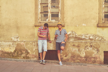 Obraz na płótnie Canvas Male friends using cellphone outdoors.