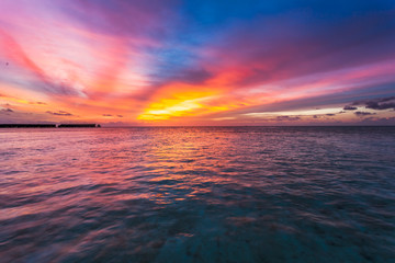 Amazing sunset over the ocean. Colorful reflection in the water.